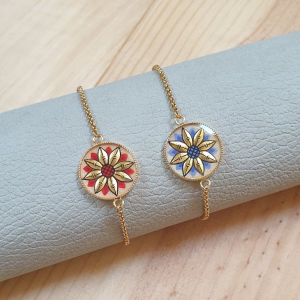 Justerbart armband med guld/bl&aring; blomdesign p&aring; guldkedja