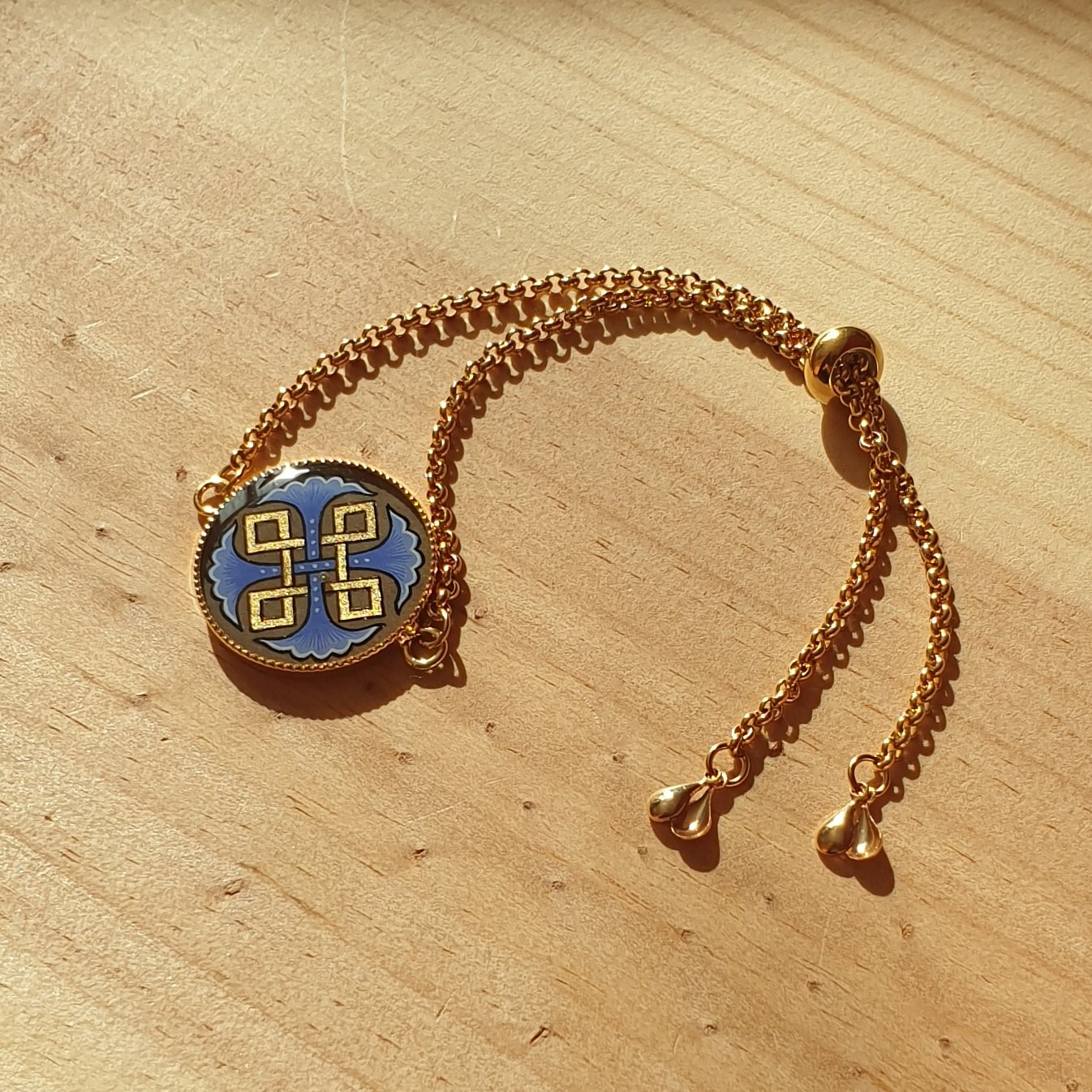 Bracelet r&eacute;glable entrelacs or et palmettes rouges ou bleues