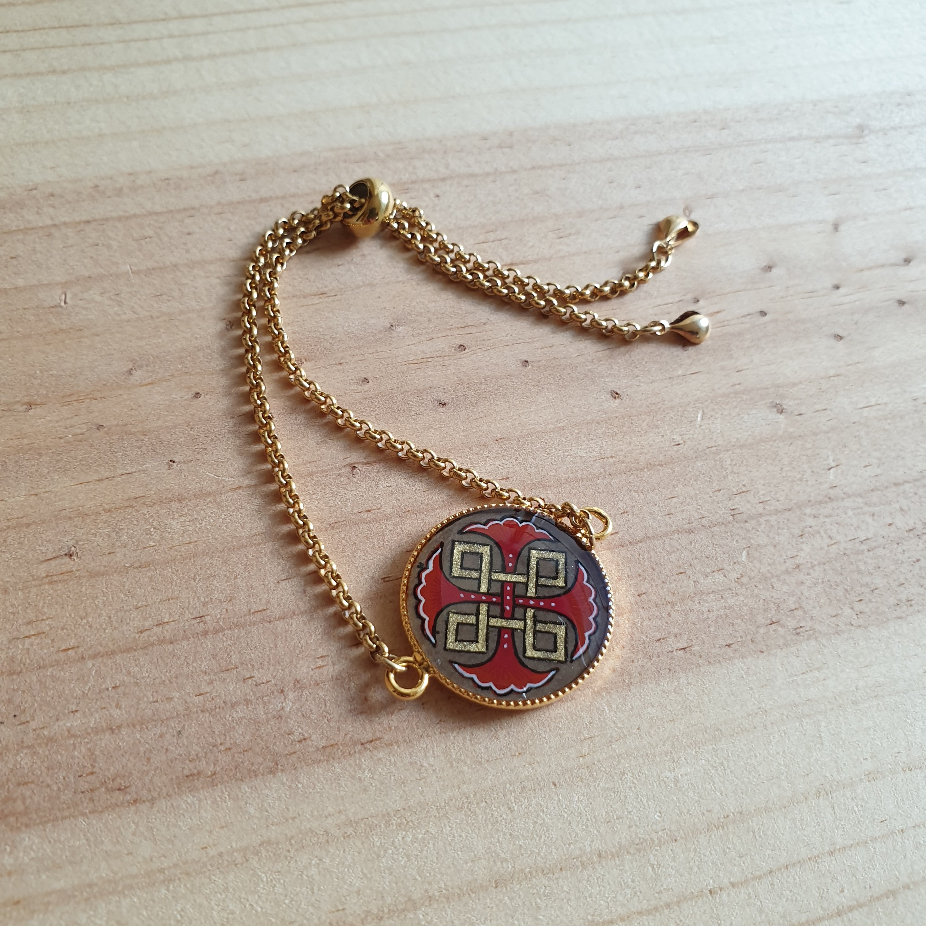 Bracelet r&eacute;glable entrelacs or et palmettes rouges ou bleues