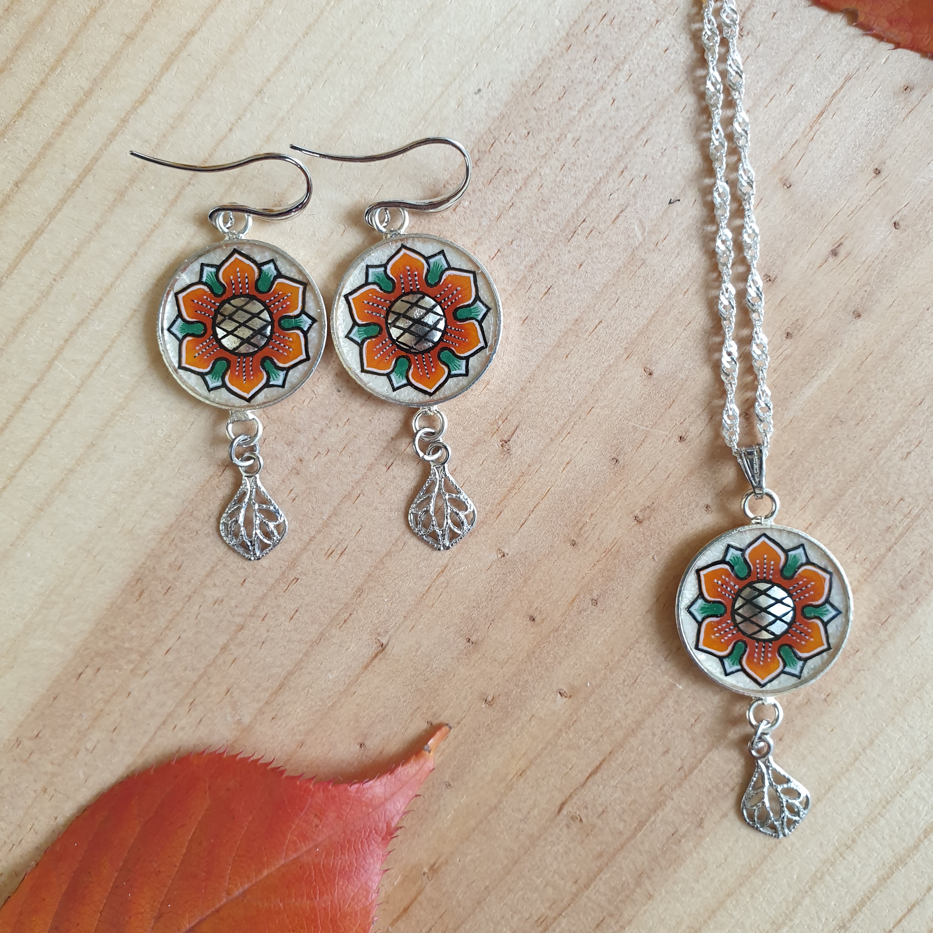 Halsband med orange/gyllene vårblomma på silverkedja