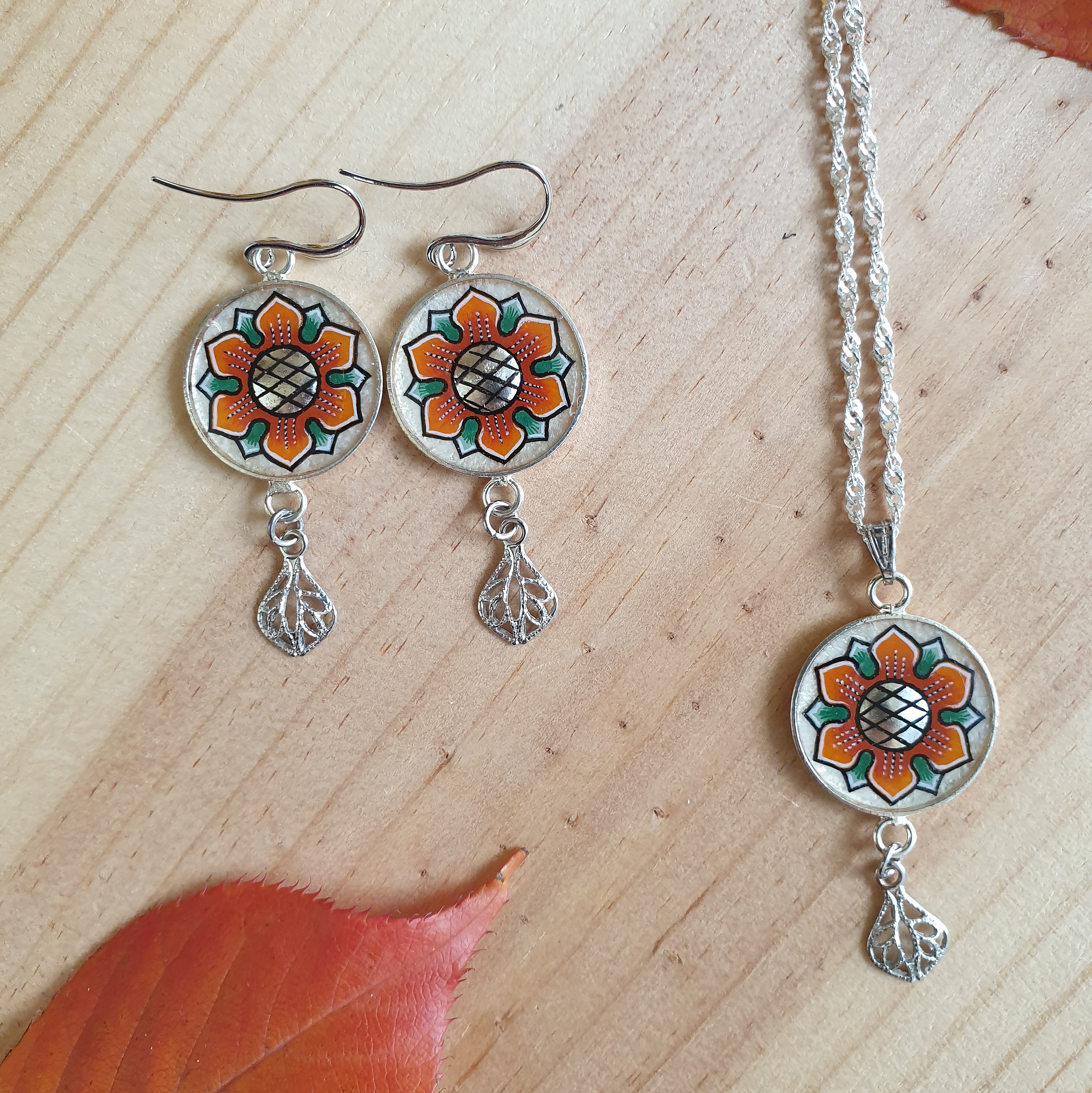 Halsband med orange/gyllene v&aring;rblomma p&aring; silverkedja