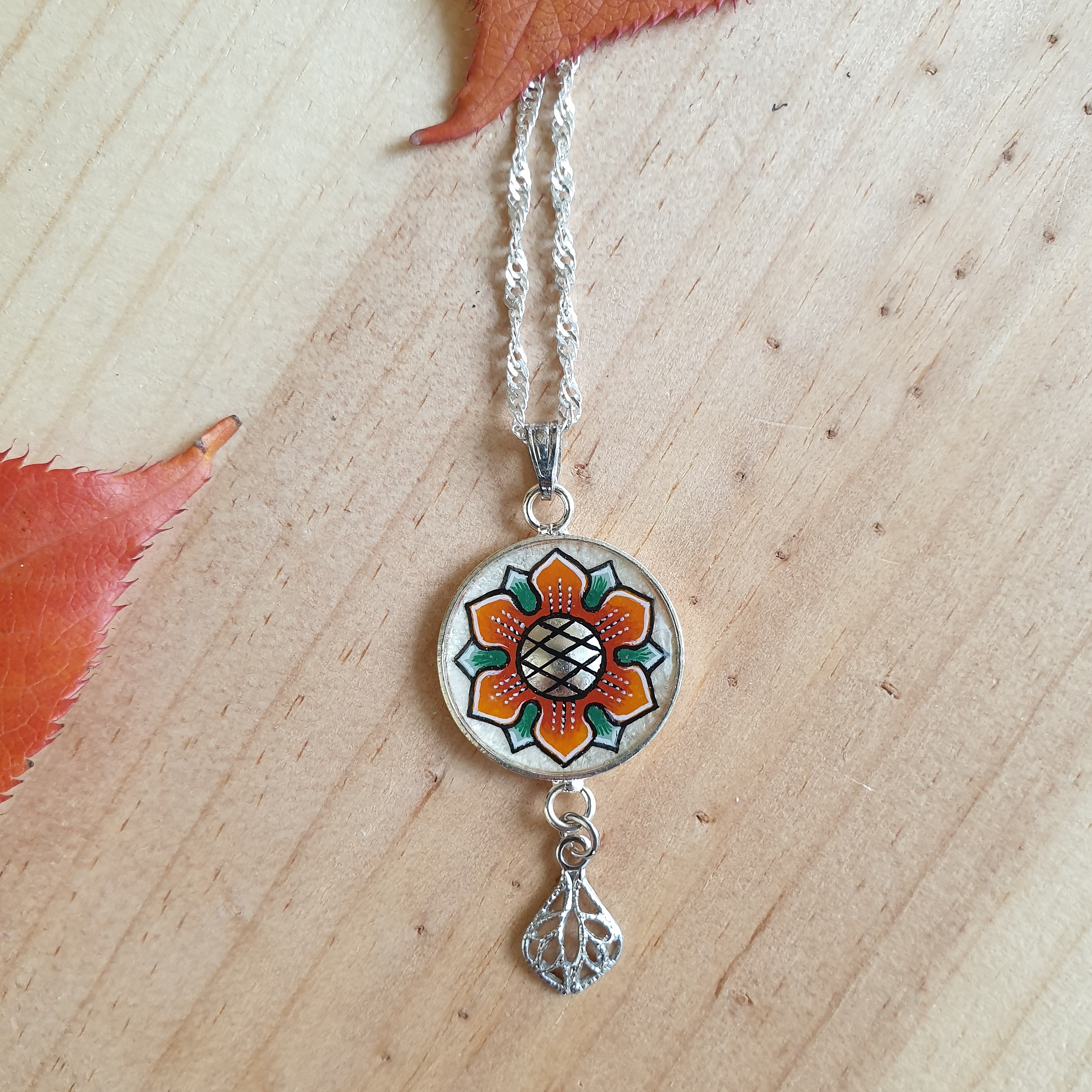 Halsband med orange/gyllene v&aring;rblomma p&aring; silverkedja
