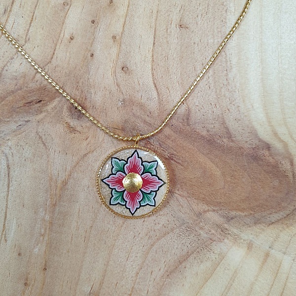 Halsband med rosa eller bl&aring; blommor p&aring; guldkedja