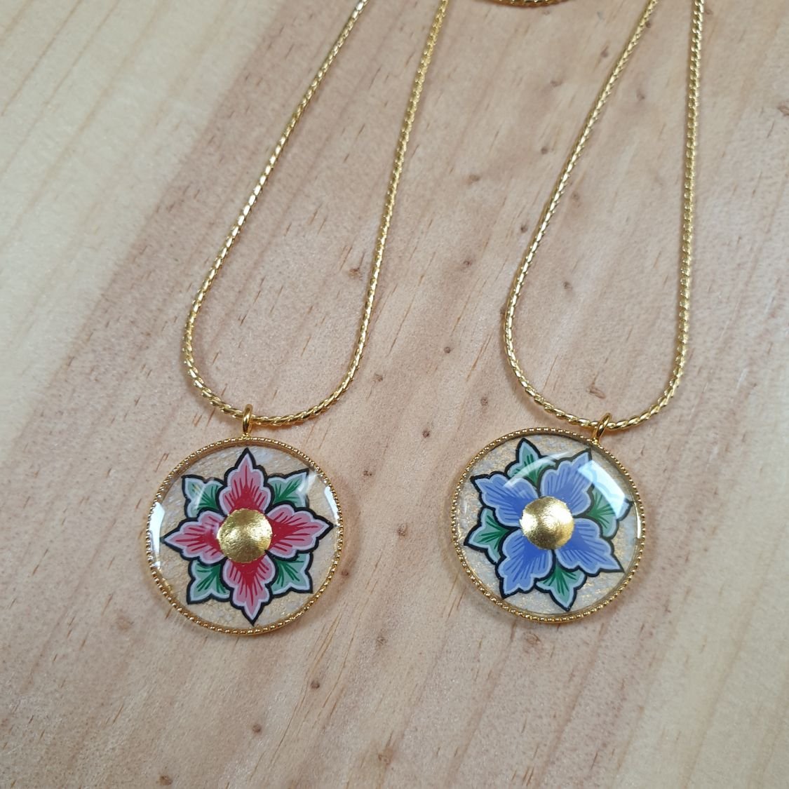 Halsband med rosa eller blå blommor på guldkedja