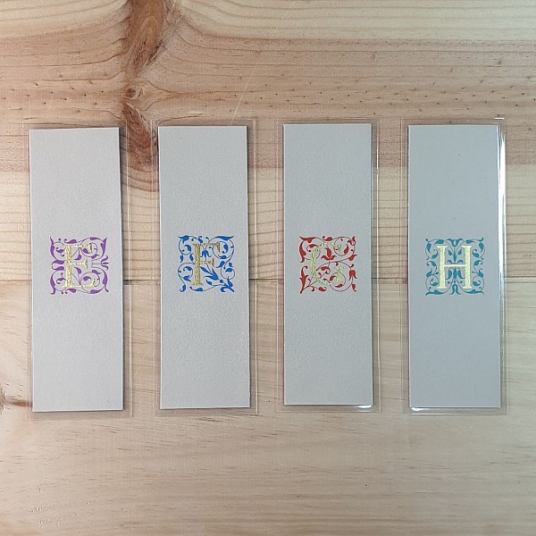 Marque-pages personnalisés avec initiales enluminées et arabesques dorées.