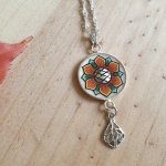 Halsband med orange/gyllene vårblomma på silverkedja